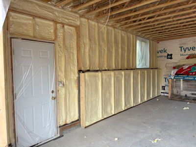 Closed-cell spray foam insulation in a residential garage wall – energy efficiency, moisture control, Pro HFO approved.